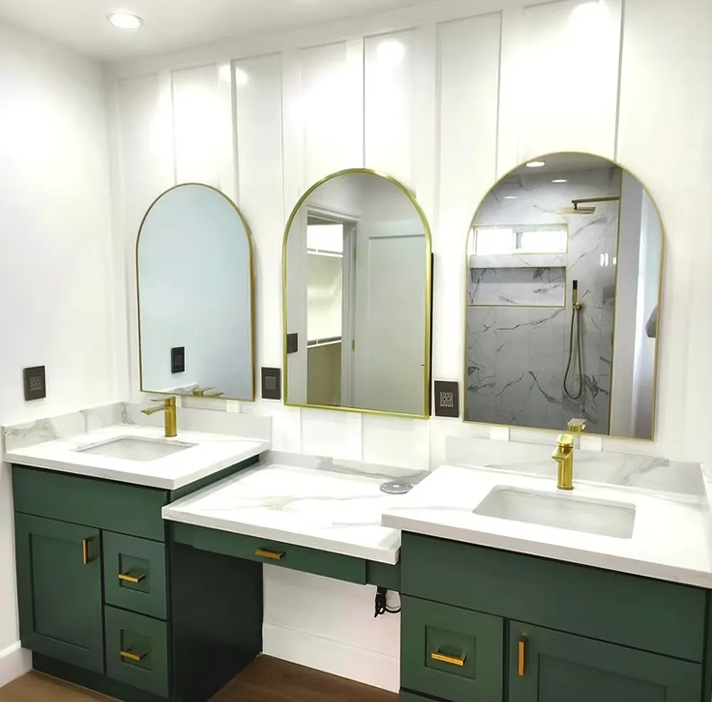 Modern bathroom remodel with green vanities and arched mirrors