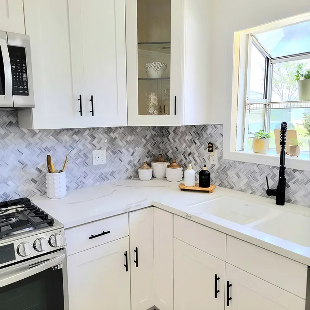 White kitchen remodel with herringbone marble backsplash